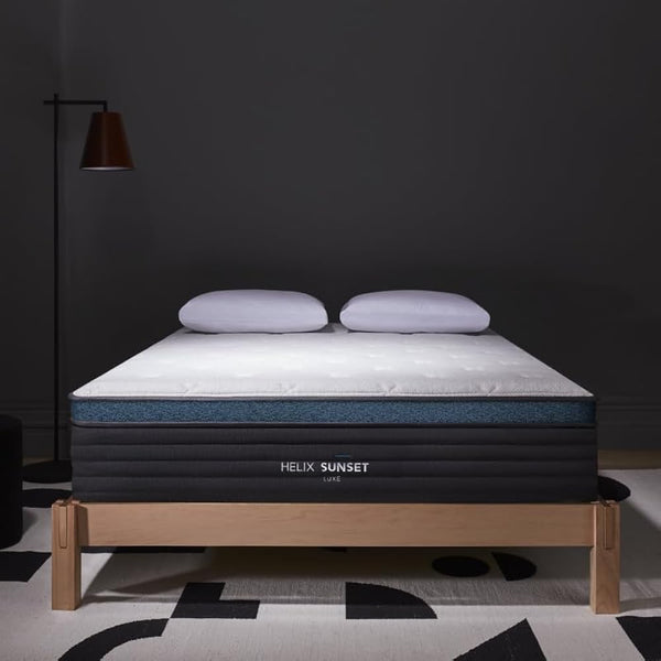 Helix Sunset mattress on a wooden bed frame with a dark wall background